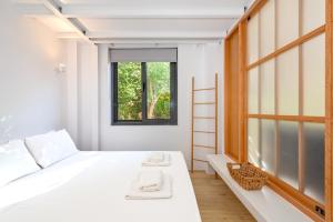 a bedroom with a white bed and a window at Central cozy garden flat in Mesochórion
