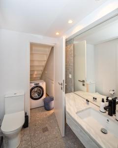 a bathroom with a toilet and a sink at Central cozy garden flat in Mesochórion +10 photos