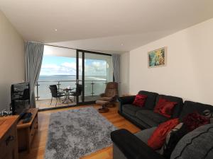 a living room with a couch and a view of the ocean at Tidal Bay in Westward Ho