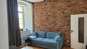 a living room with a blue couch in front of a brick wall at Šumavská pohoda Zdíkovec 21 in Zdíkov
