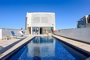 a swimming pool on the roof of a building at Stay Inn Santos Sua acomodação com cara de Hotel in Santos