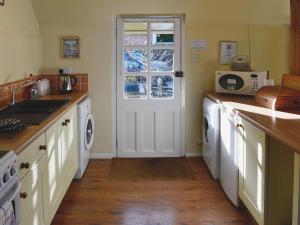 a kitchen with a washer and dryer at Bat's Cottage in Tipton Saint John +6 photos