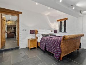 ein Schlafzimmer mit einem großen Bett mit einer lila Decke in der Unterkunft Temple Cottage in Abercastle + 9 Fotos