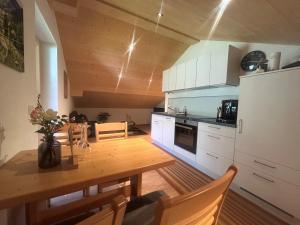 een keuken met een houten tafel en een koelkast bij Haus Lechner in Gaschurn