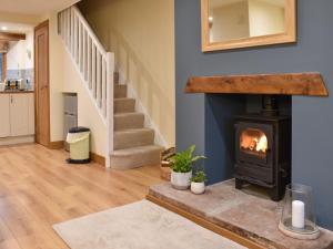 a living room with a fireplace and stairs at Pippa's Cottage - Uk42332 in Little Blencow