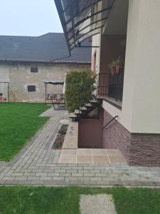 a house with a staircase and a bench in a yard at Ubytovanie v súkromí 85 suterén in Bešeňová +5 photos