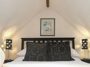 1 dormitorio con 1 cama con almohada y 2 lámparas en Blue Charm - 29585, en Damerham