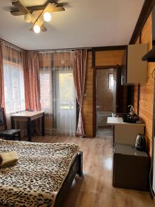 a bedroom with a bed and a kitchen and a sink at SONATA Чан біля річки in Skole