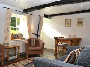ein Wohnzimmer mit Sofa und Tisch in der Unterkunft Blease Cottage in Threlkeld