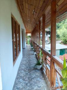 a porch of a house with a wooden ceiling at Tirthan Majestic View Homestay in Kulu