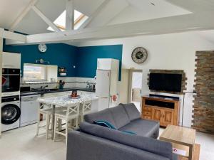 a kitchen and living room with a couch and a table at L'étable de Keriven in La Chapelle-Neuve +12 photos