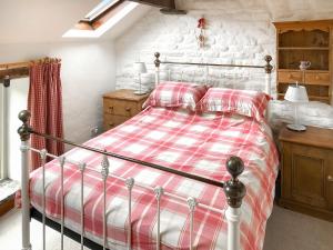 a bedroom with a bed with a red and white blanket at Cotton Cottage in Hope