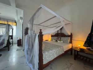 un dormitorio con una cama con dosel en Nungwi Retreat, en Nungwi