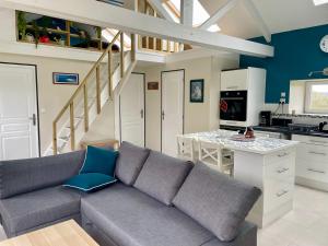a living room with a couch and a kitchen at L'étable de Keriven in La Chapelle-Neuve