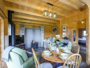 a living room with a table and a couch at Stable Lodge At Greenacre in Bromyard