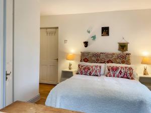 ein Schlafzimmer mit einem großen Bett mit roten Kissen in der Unterkunft Kielder Cottage Spa - E3533 in Kielder + 9 Fotos