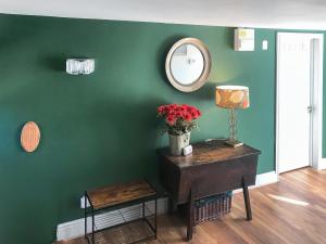 Zimmer mit einer grünen Wand mit einem Tisch und einem Spiegel in der Unterkunft Kielder Cottage Spa - E3533 in Kielder