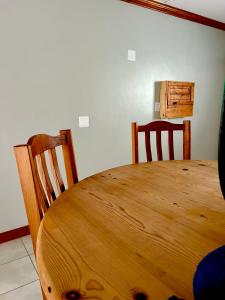 a wooden table and two chairs in a room at Colline Sainté Cottage in Port Alfred +4 photos