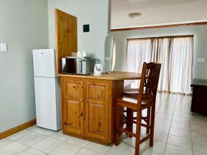 a kitchen with a table with a mirror and a refrigerator at Colline Sainté Cottage in Port Alfred