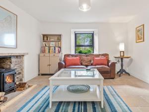 a living room with a couch and a fireplace at Morfa Ganol in Llangranog +22 photos