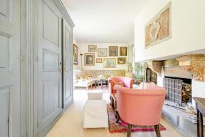 sala de estar con sillas rosas y chimenea en Antica Cascina del Medico, en Muzzano