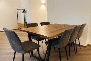 - une table et des chaises en bois dans l'établissement YFB-170m2 Apartment für bis zu 15, modern, 1min zu UBahn, Ruhige Lage, Parkplätze, WIFI, Netflix, Kindergerecht, à Nuremberg 12 autres photos