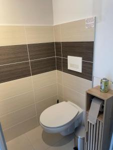a bathroom with a white toilet in a room at L'étable de Keriven in La Chapelle-Neuve