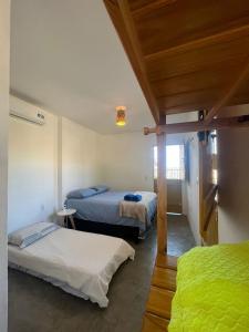 a bedroom with two beds in a room at Mar Aberto Chalé 4 in Barroquinha