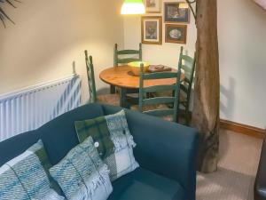 MelmerbyにあるElseghyll Barnの青いソファとテーブルのあるリビングルーム
