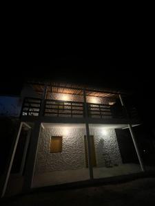 a building with lights on the side of it at night at Mar Aberto Chalé 4 in Barroquinha