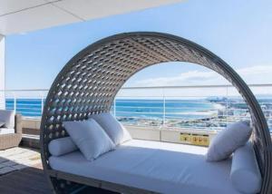 a wicker bed in a room with a view of the ocean at Nova Stay Gangneung in Chumunjin