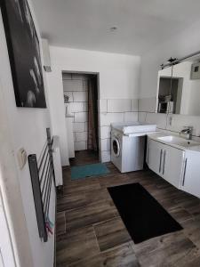 a bathroom with a washing machine and a sink at Ferienhaus An der Brunnenaue in Stralsund