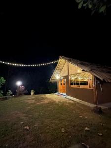 a building with lights on the side of it at night at Pepper Hills Hostel & Cottages in Ella