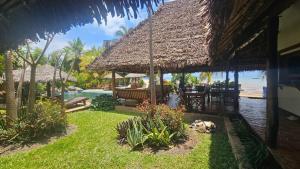 a resort with a swimming pool and a thatch roof at La Vie Est Belle in Ambaro