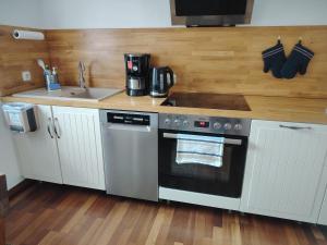 a kitchen with a stainless steel oven and a sink at Ferienhaus An der Brunnenaue in Stralsund