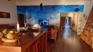 a living room with a blue wall with a fish mural at La Vie Est Belle in Ambaro