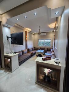 曼苏里亚Confort & Emplacement, Pieds dans l'eau的客厅里有一张沙发和一台电视