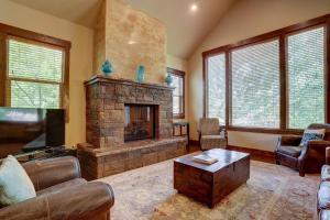 ein Wohnzimmer mit einem Steinkamin und einem TV in der Unterkunft Points West in Deschutes River Woods