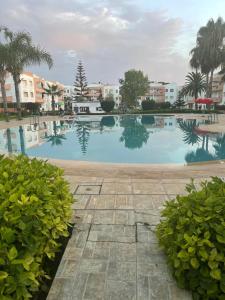 a large swimming pool with some trees and buildings at Confort & Emplacement, Pieds dans l'eau in Mansouria
