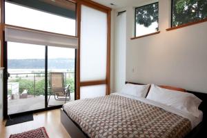 een slaapkamer met een bed en een balkon met een stoel bij Bridge View Loft 30 Day in Hood River +10 foto's