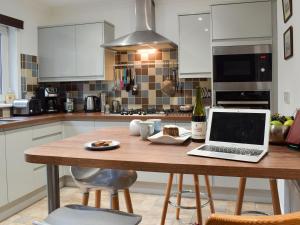 a kitchen with a table with a laptop on it at Tigh Raineach in Strathyre +14 photos