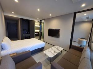 a bedroom with a bed and a flat screen tv at Nova Stay Gangneung in Chumunjin