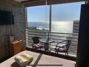 a bedroom with a balcony with a table and chairs at Pingel Apartment Vista Mar in Viña del Mar