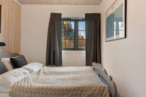 een slaapkamer met een bed voor een raam bij Trysilfjell 752E by Vacation Trysil in Trysil