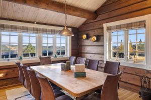 a dining room with a wooden table and chairs at Trysilfjell 615 by Vacation Trysil in Hovi
