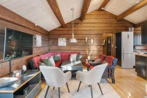 a living room with a red couch and white chairs at Trysilfjell 615 by Vacation Trysil in Hovi