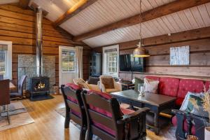 a living room with a red couch and a fireplace at Trysilfjell 615 by Vacation Trysil in Hovi +25 photos