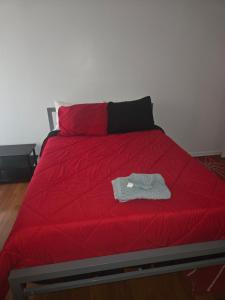 uma cama com um edredom vermelho e uma camisa em cima. em Humble Abode em Stone Mountain