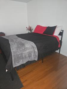 uma cama com um edredão preto e almofadas em Humble Abode em Stone Mountain