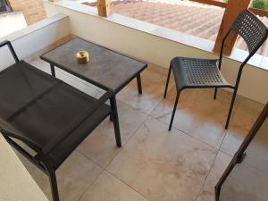 two chairs and a table and a chair on a balcony at Elania Residence in Târgu Jiu